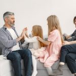 A joyful family spends quality time together, playing and bonding on a cozy sofa.